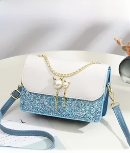 Detail view of blue sequin crossbody bag with pearl cat charms and chain trim