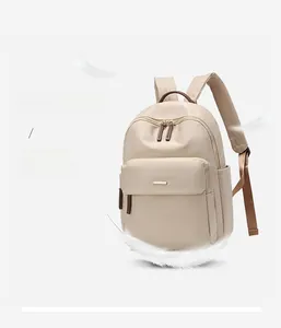 Detailed view of lightweight beige nylon backpack with contrasting brown handle and side pockets