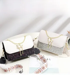Detail of mini flap bag with sequin patchwork, pearl cat hardware and snowflake strap