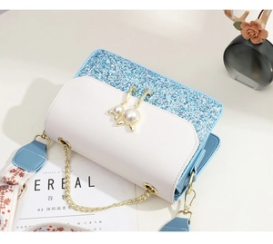 Detail of glitter shoulder bag with cat pearl pendant and floral jacquard strap