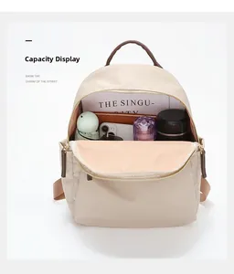Detail view of the beige oxford backpack showing spacious interior and storage capacity