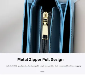 Close-up of sky blue leather bag featuring a smooth gold zipper pull and inner compartment