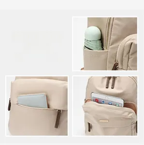 Detail view of multi-pocket storage for tablet, umbrella and cards on beige oxford backpack