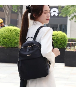 Detailed view of black waterproof oxford backpack with premium gold metal zippers