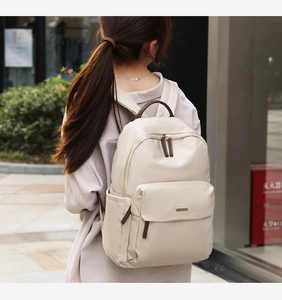 Modern beige oxford cloth backpack with brown leather trim and gold-tone zippers