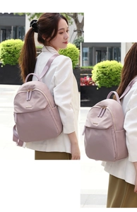 Close-up of pink oxford travel backpack with golden zippers and side pocket detail