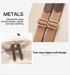 Détail des boucles dorées réglables et de la fermeture éclair à double sens en métal