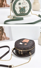 Detail view of round crossbody bags featuring embroidered bear and metallic chain straps