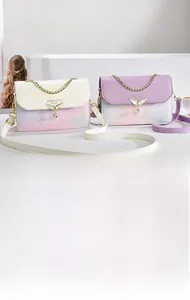Détail du sac bandoulière en similicuir fleuri avec boucle ailée et chaîne dorée élégante
