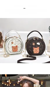 Detail view of round crossbody bags in beige and brown with cute 3D bear decoration
