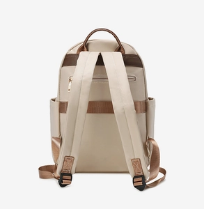Detail of waterproof beige fabric backpack featuring adjustable shoulder straps and top handle