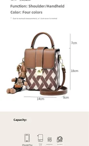 Détail du sac bandoulière avec texture tissée bicolore, fermoir métal et breloque