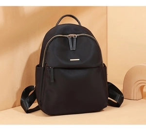 Detailed shot of black waterproof nylon backpack with golden metal zippers and side pockets