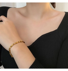 Detailed close-up of golden Mobius titanium steel bracelet with twisted texture design