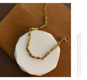 Close-up of golden Mobius titanium steel bracelet with twisted geometric links and lobster clasp