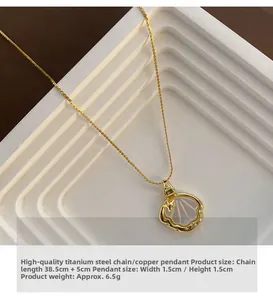 Vue détaillée d'un collier pendentif coquillage doré sur un support blanc