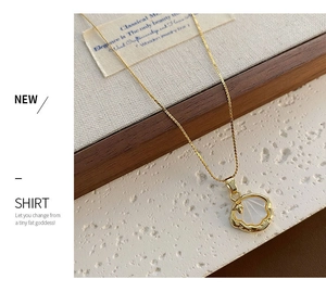 Détail d'un collier coquillage doré avec incrustation de nacre et détails d'étoiles