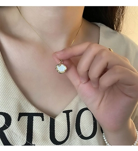 Gros plan d'un collier pendentif coquillage doré avec incrustation de nacre sur mannequin