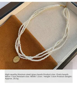 Dettaglio della collana di perle a più strati con ciondolo ovale in titanio dorato