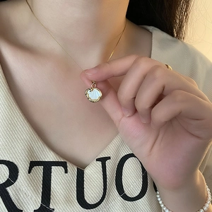 Collier élégant en nacre dorée avec étoile sur mannequin en pull en maille beige