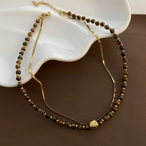 Double-layered tiger eye stone bead necklace with a gold snake chain and spherical pendant