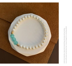 Macro detail of beaded pearl bracelet with light blue glass beads and gold spacers