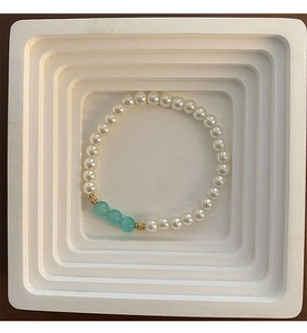 Detailed view of pearl bead bracelet with mint green glass beads and gold spacers
