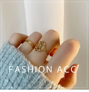 Detailed close-up of a two-piece gold titanium steel ring set with geometric hollow design