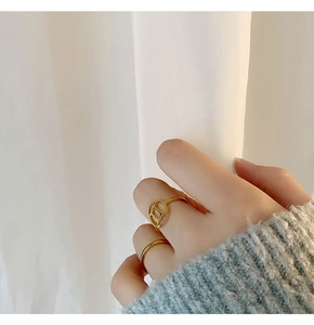 Detail view of two gold titanium rings featuring a Chaine d'Ancre style design on fingers