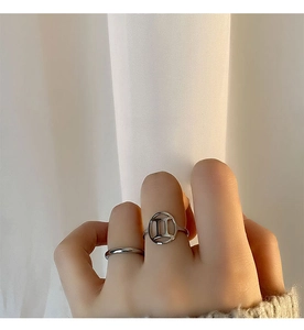 Macro shot of silver Gemini constellation rings and minimalist band set on a woman's hand
