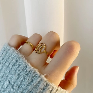 Minimalist gold Gemini zodiac sign ring set worn with cozy grey knit sleeve