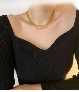Gros plan d'un collier doré à double épaisseur avec chaîne à maillons et chaîne serpent
