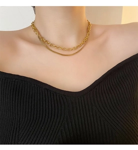 Détail d'un collier double rang doré avec chaîne serpent et maillons sur mannequin