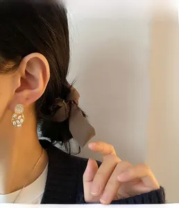 Detailed shot of French vintage gold earrings with rhinestones and inlaid small pearls
