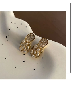Detailed macro view of vintage pearl drop earrings with sparkling pavé crystals