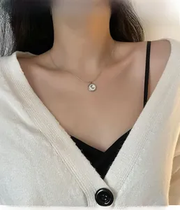 Detail of silver crescent moon necklace with white shell pendant on model neck