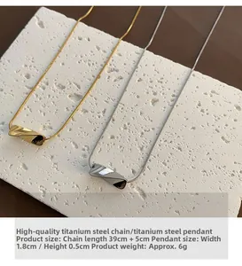 Detail view of gold and silver titanium necklaces with 39+5cm chain on stone display