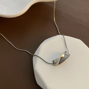 Minimalist silver twist rectangular pendant necklace with sleek snake chain on display