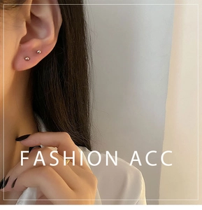 Close-up of minimalist silver ball stud earrings worn on the ear for a stylish daily look