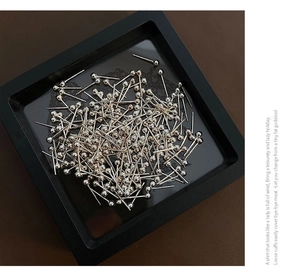 Detailed view of bulk sterling silver ball stud earrings stacked in a black jewelry tray