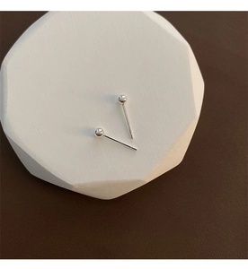 Macro detail of minimalist silver ball studs showing S925 hallmark on a white tray