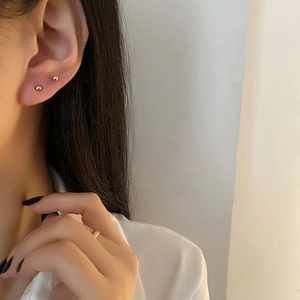 Minimalist sterling silver ball stud earrings shown on model for stacked styling