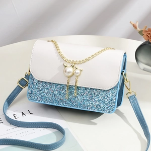 Blue sequin crossbody bag with white leather flap and pearl cat charm on chain strap