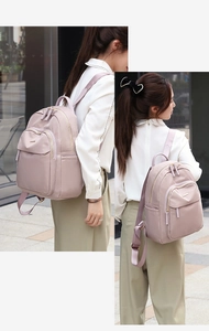 Vue détaillée du sac à dos en nylon rose avec tissu haute densité et poche latérale