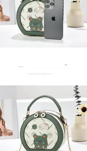 Close-up of green and cream round leather crossbody bag with cartoon bear print