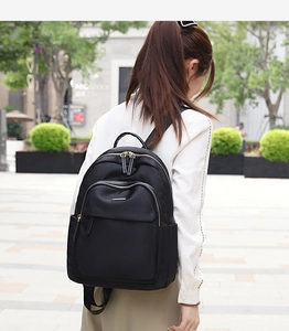 Vue extérieure d'un sac à dos en nylon noir avec des fermetures éclair dorées élégantes