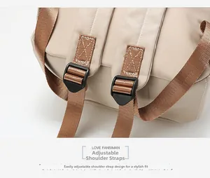 Close-up of adjustable brown woven shoulder straps on a beige oxford fabric backpack