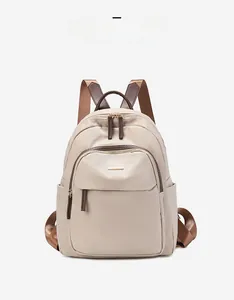 Vue de face du sac à dos en nylon beige imperméable avec bretelles marron et poches