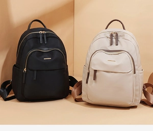 Détail de sacs à dos en tissu Oxford noir et beige avec logo métallique élégant
