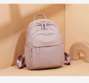 Vue détaillée du sac à dos en nylon violet imperméable avec fermetures éclair dorées